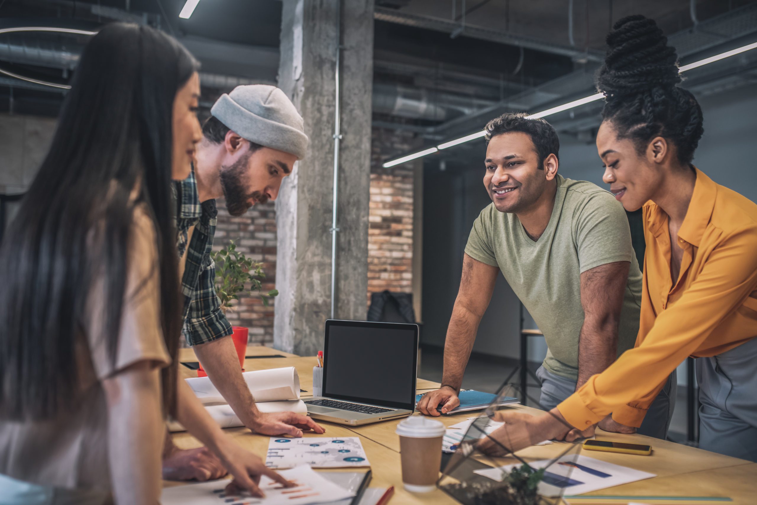 Four interracial smiling people in office Skyrocket